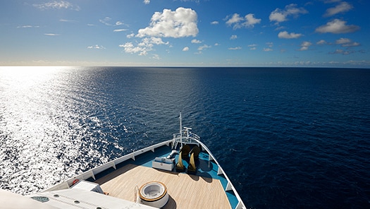 Bow of a cruise ship overlooking ocean horizon