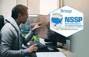 asian male pointing at computer with rnssp hexagon logo on right