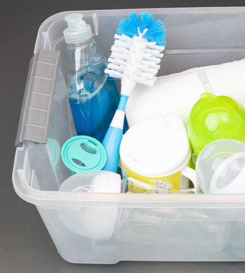 A plastic bin filled with cleaning supplies