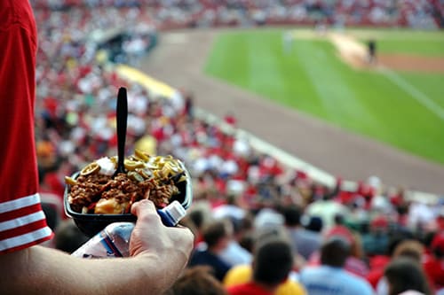 A sports fan holding a bowl of stadium food