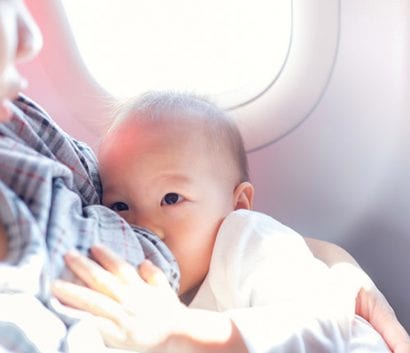 A baby breastfeeding on a plane