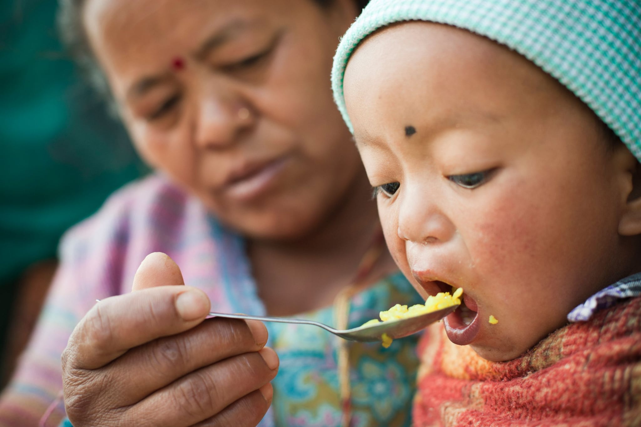 Asian woman feeding young child