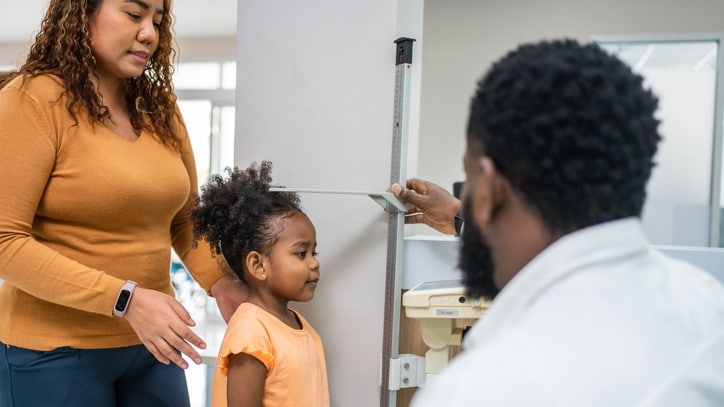 Doctor measuring young girl's height