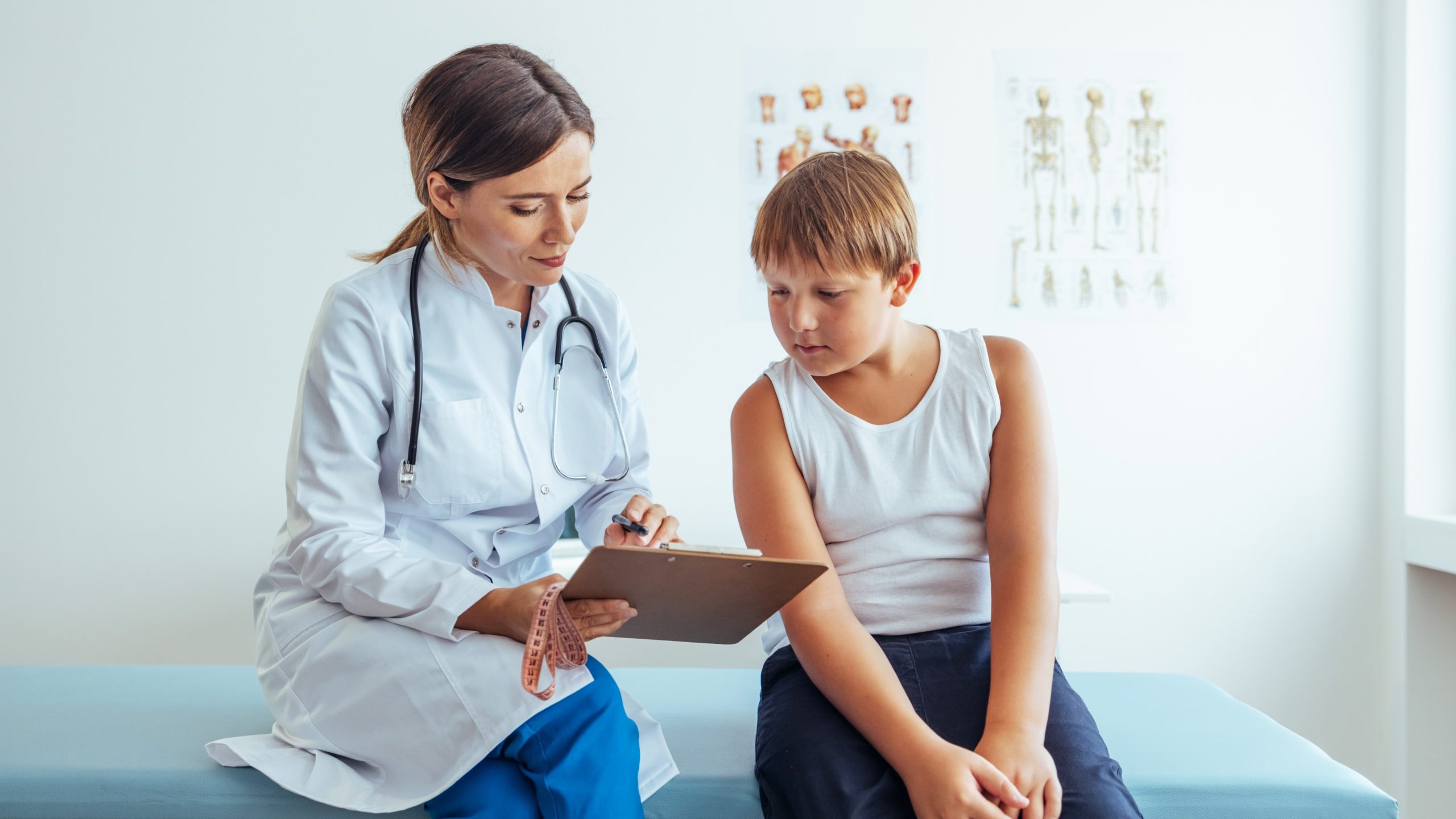 female doctor and young male patient looking at clipboard