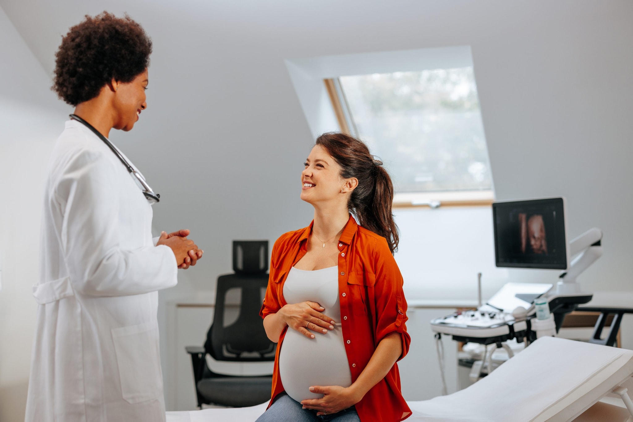 A pregnant woman talking to her female health care provider.