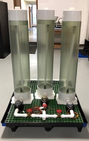 New technology: three clear plastic columns hold fluoridated water for rural communities