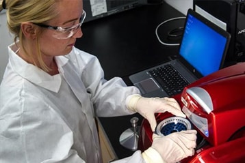 female scientist working in a lab wearing protective glasses