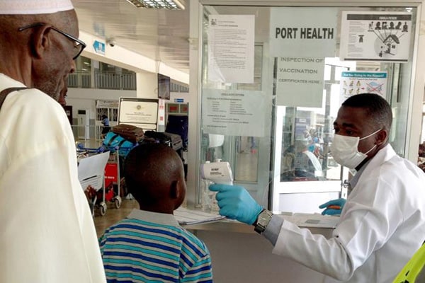 masked doctors looking over a small Afrikan boy