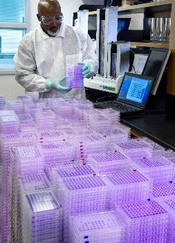 A CDC Polio Population Immunity team researcher loads completed serology assay plates into a microplate reader for analysis. The serology study was to support ongoing research with CDC’s clinical partners. The focus of the serology team is to advance development of new and improved polio vaccines. CDC Photo, James Gathany.