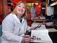 Christine J. Morrison, PhD, holds a great number of patents in CDC’s portfolio. In the photo, Dr. Morrison (with technician, Steve Hurst, in the background) is analyzing some of her laboratory data related to molecular probe diagnostics.