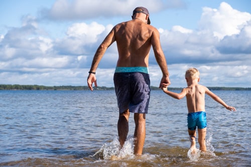 Father and son walking in water