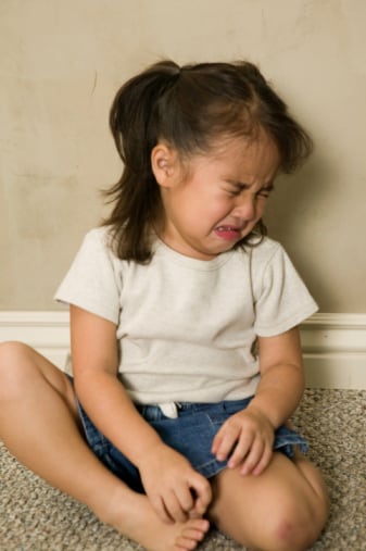 Little girl sitting on floor crying