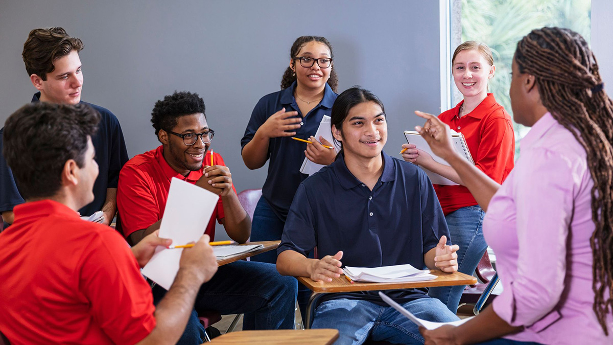 Teacher, high school students having group discussion