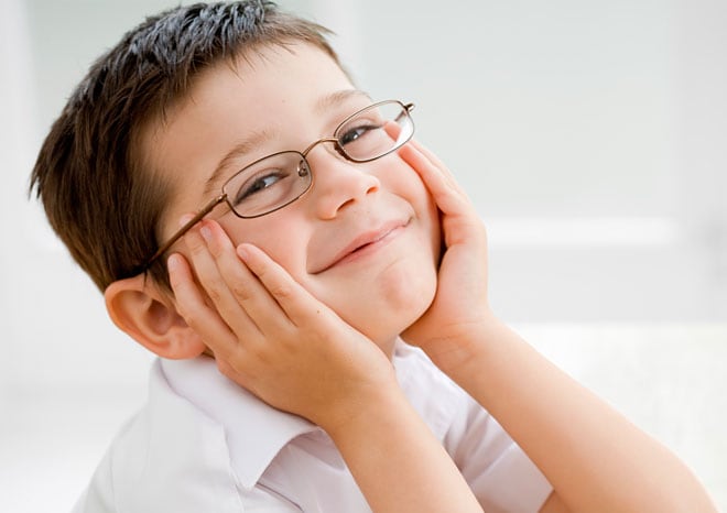 Young child holding his face between his hands and smiling