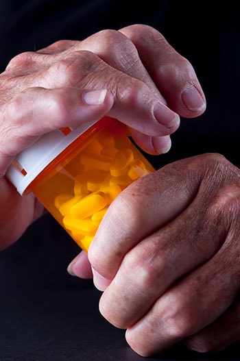 Hands securing a medication bottle lid