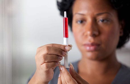 Woman measuring medicine in a syringe