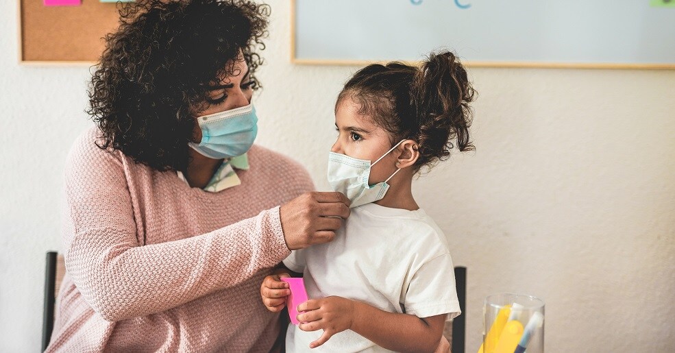 Mother sets up surgical mask on her daughter while teach at home - Coronavirus lifestyle and prevention