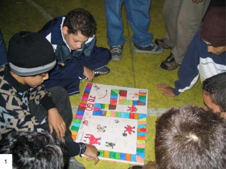 Photo of young people studying a board game