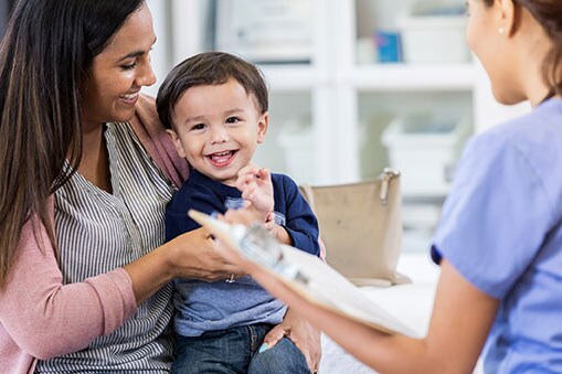 Cheerful toddler boy enjoys pediatrician visit.