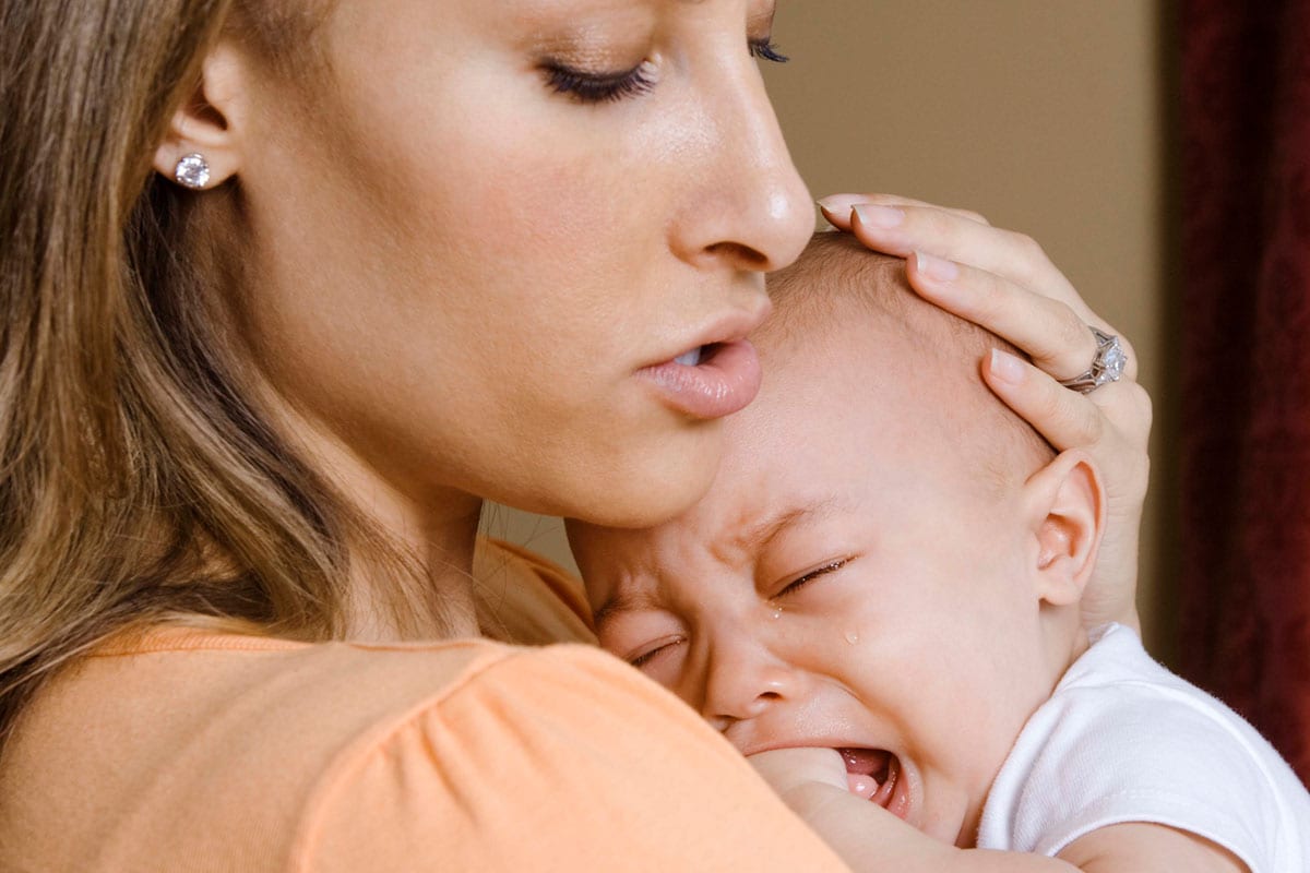Madre sosteniendo a su bebé que llora