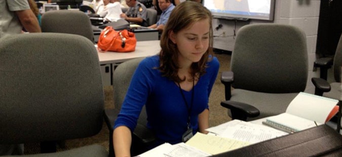A busy associate working with multiple documents on her desk