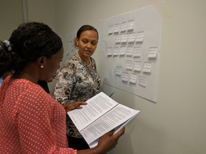 PHIFP fellows (l-r): Loretta Amadi and Ester Mungure strategize during a PHIFP learning session in August 2017