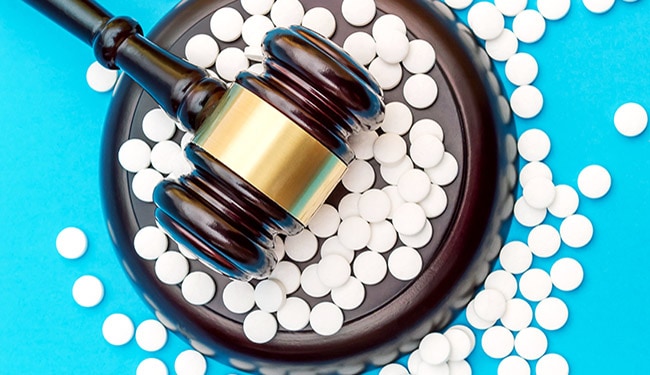 Photo: Gavel with white pills on blue