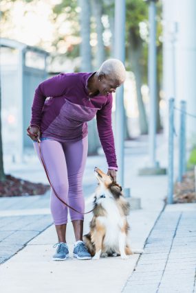 A senior woman walking with her dog