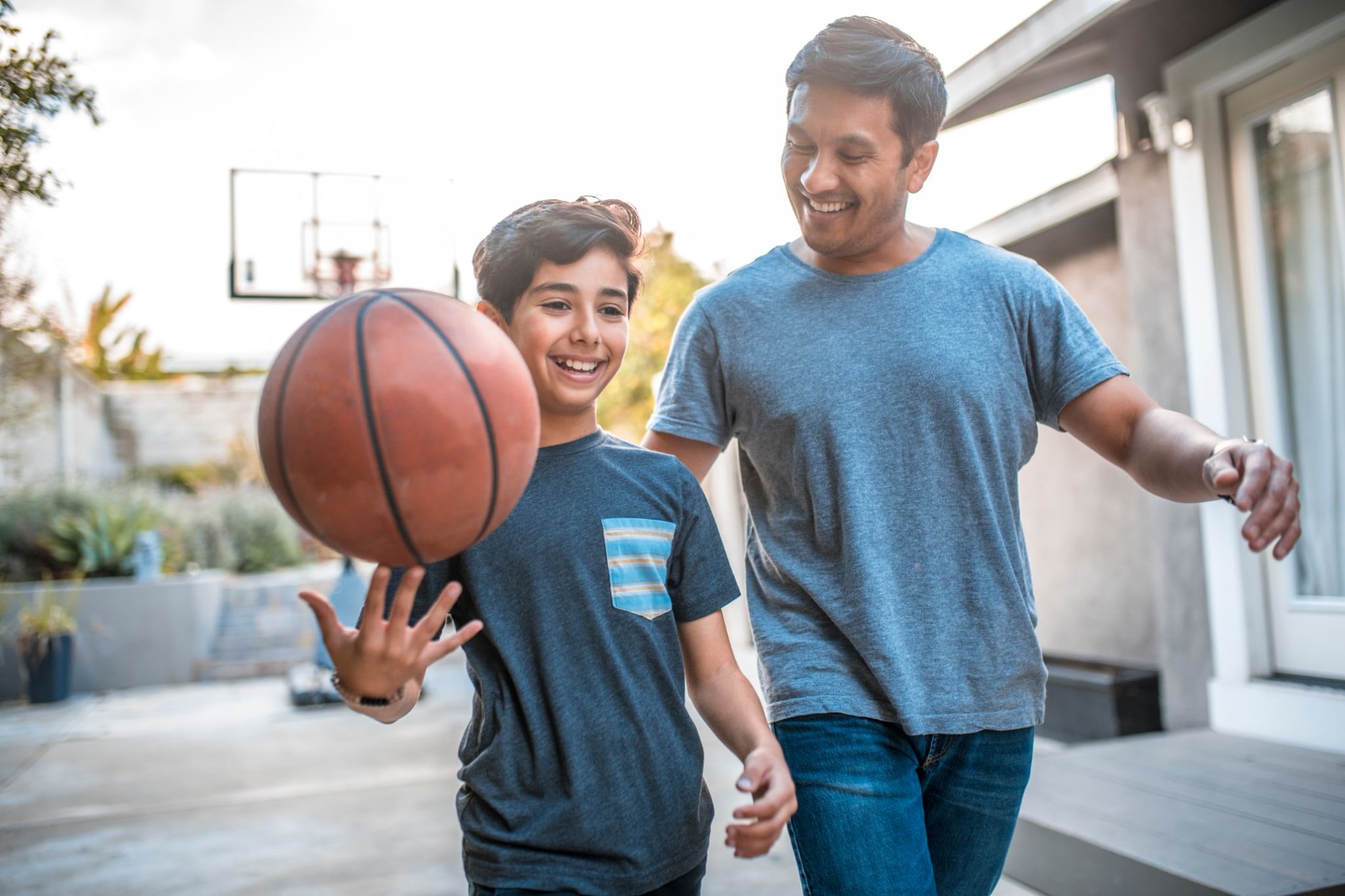 Padre e hijo hispanos girando baloncesto