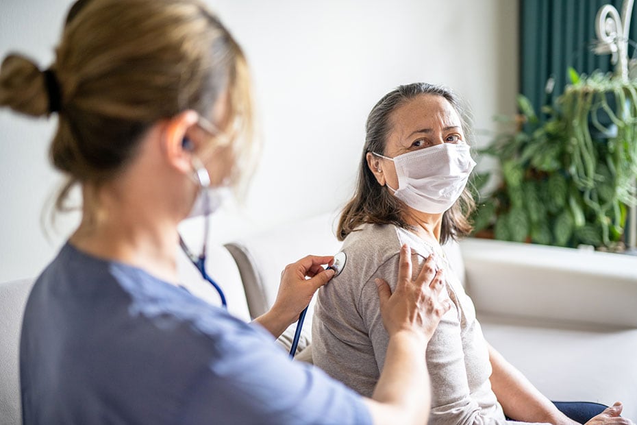 healthcare worker listens to patient's lungs