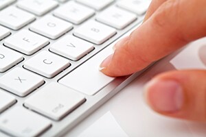 laptop keyboard with finger pressing on spacebar