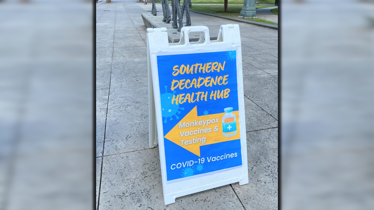 A Southern Decadence Health Hub sign advertising vaccination for mpox and COVID-19 greets visitors at the main entrance to Armstrong Park in New Orleans, Louisiana