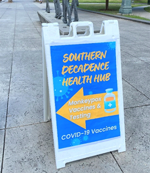 A Southern Decadence Health Hub sign advertising vaccination for monkeypox and COVID-19.