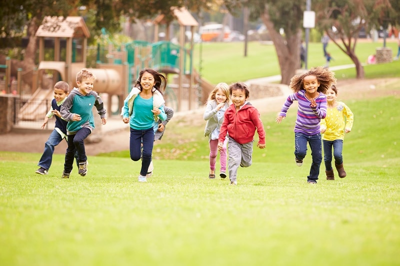 A group of children running in a park