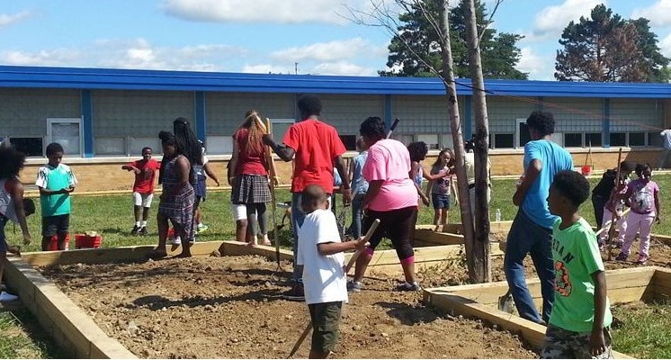 Children and adults work together to create a community garden in Flint, Michigan.