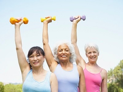 Three older women lifting dumbbells