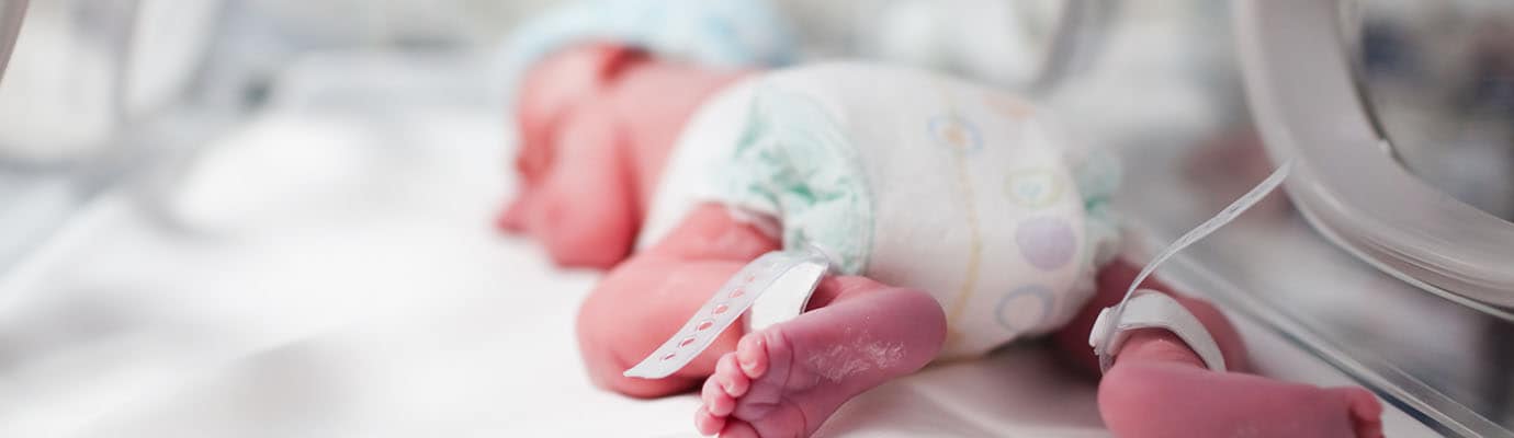 Newborn baby boy covered inside incubator