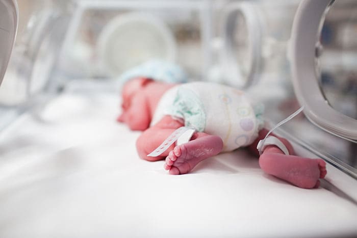Newborn baby boy inside incubator