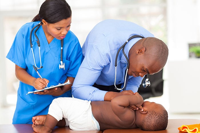 Doctor and nurse doing checkup on little boy