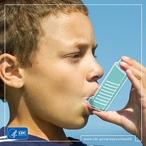 Young boy holding asthma inhaler