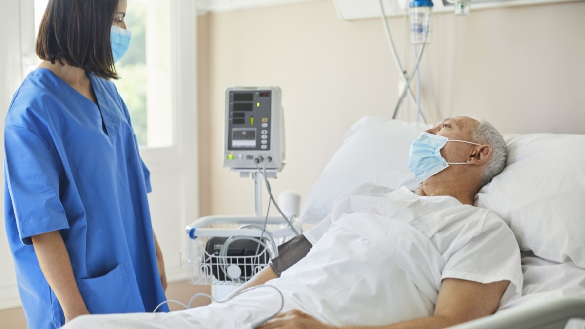 Foto de un hombre en un hospital hablando con una enfermera