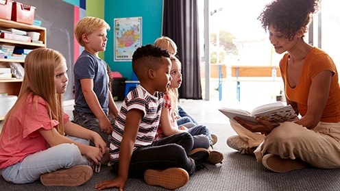 Teacher reading to children in a classroom.