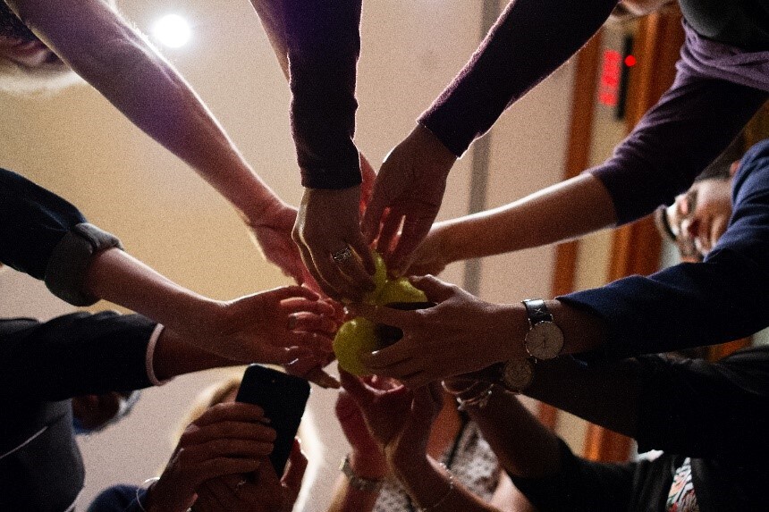 Photo of hands joining as a team during an interactive session at PHIT in 2019. 