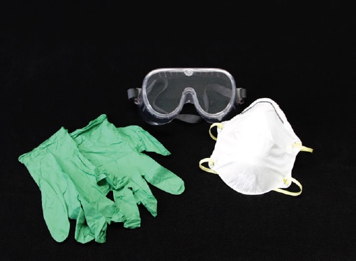A pair of safety goggles, a dust mask, and a pair of rubber gloves on a black background