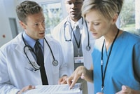 three doctors reviewing medical charts