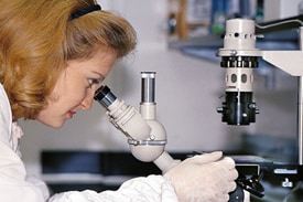 woman looking at microscope