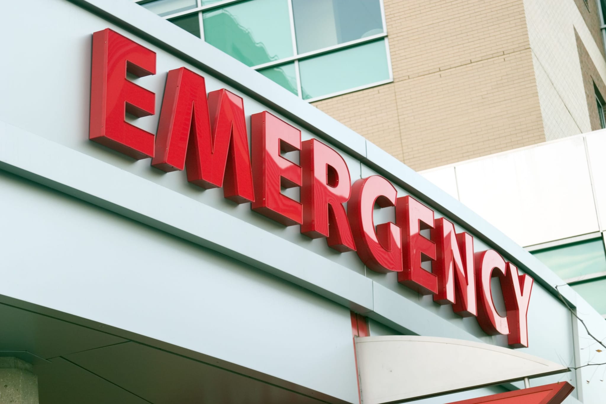 A large red-lettered "Emergency" sign on a hospital façade indicating the entrance to an emergency department