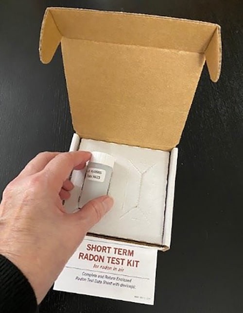 A short-term radon testing kit in a white box.