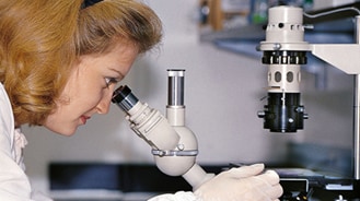 image of researcher looking through a micrscope.