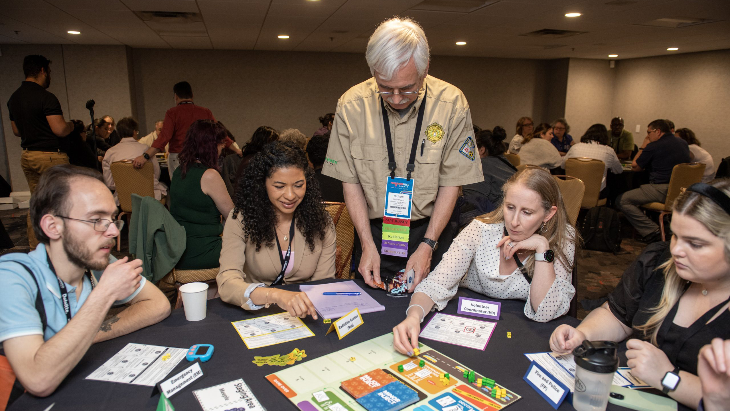 Group of people around table playing TEST.